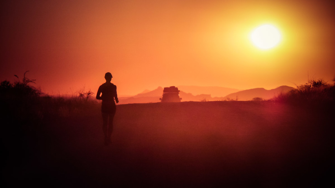 Picture of a woman running towards the sunset in Africa 