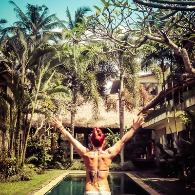 Woman standing triumphantly in tropical Bali