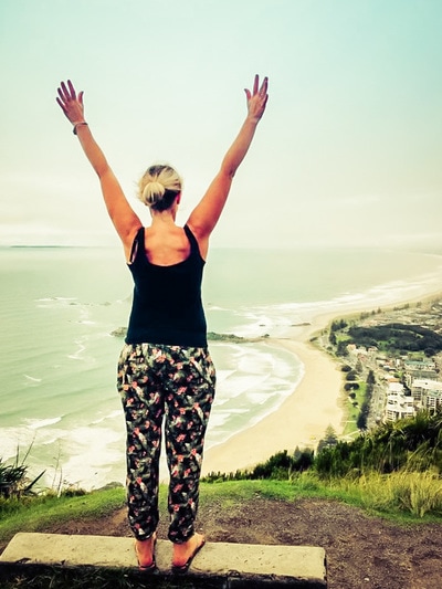 Woman gleefully standing over scenic lookout