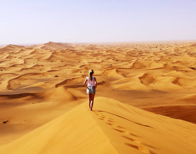 Woman standing overlooking stunning desert outside Dubai
