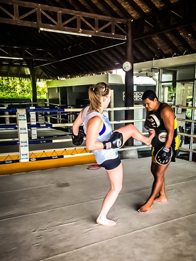 Woman kicking while Thai boxing training