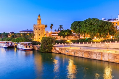 Sparkling Seville next to the water in twilight
