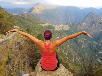 Woman posing triumphantly in Peruvian mountains - Machu Picchu