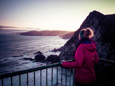 Woman overlooks the wild coast of New Zealand's South Island