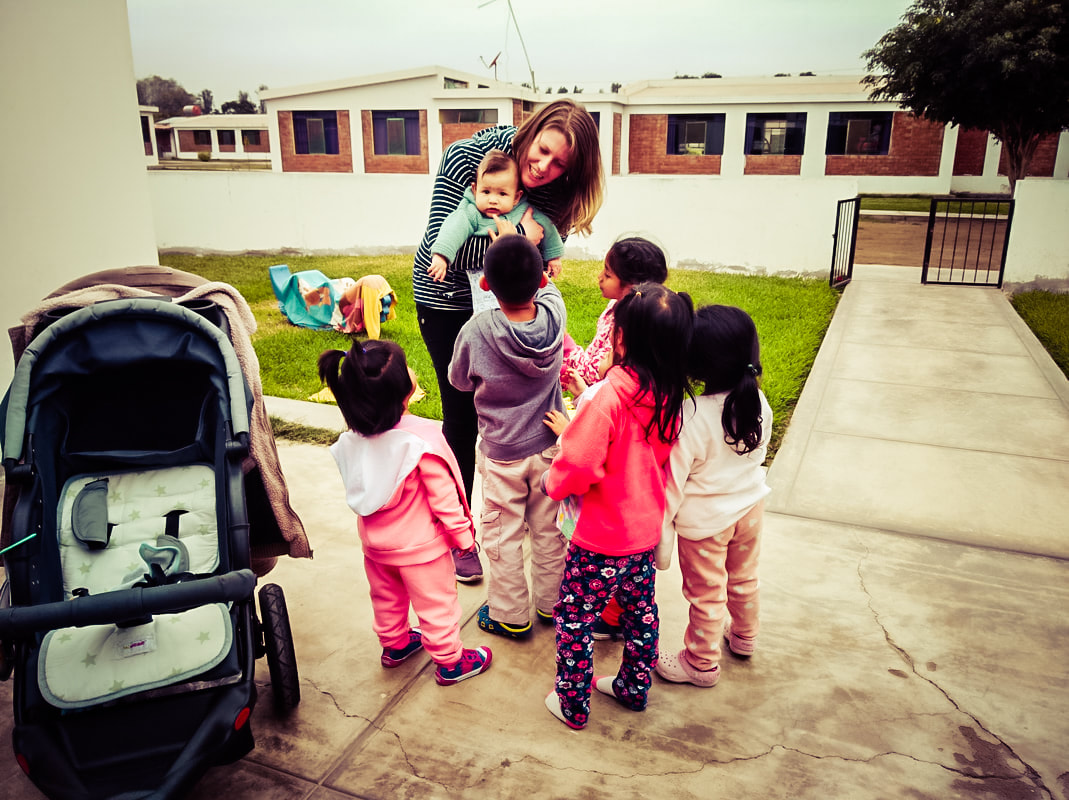 Picture of children in a children's home in Peru welcoming a mum and baby visiting them 