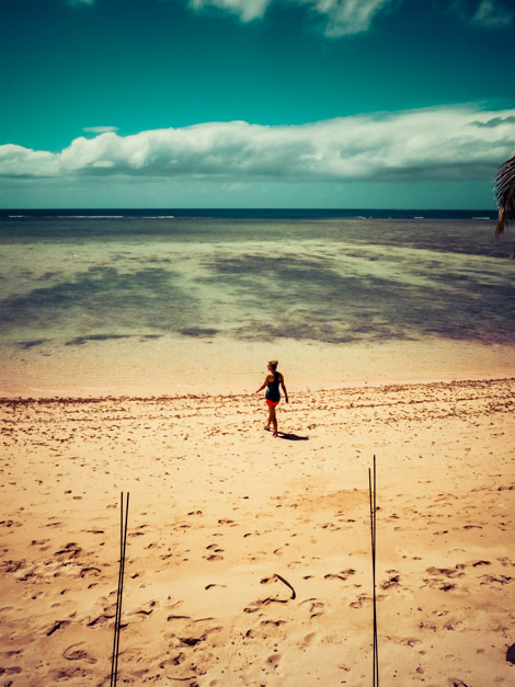 Woman standing alone on sandy Samoan shore