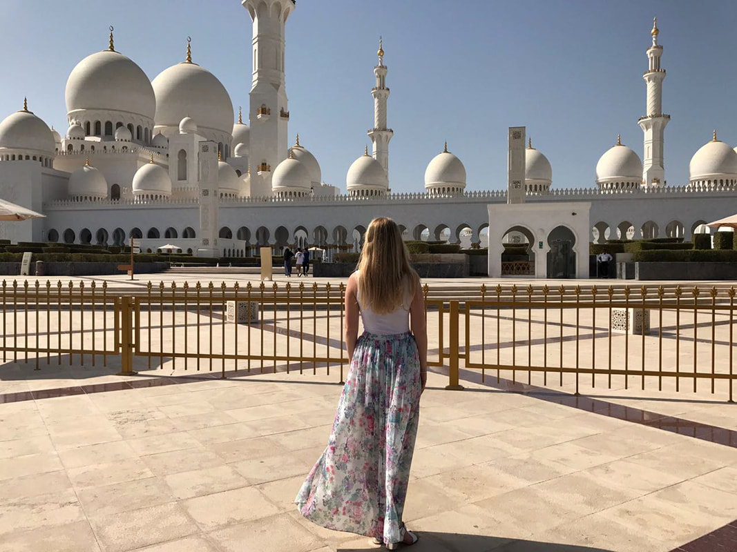 Picture of a woman standing in front of the Sheikh Zayed Mosque in Abu Dhabi 