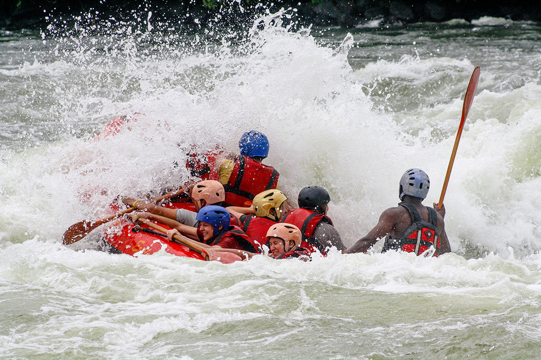 A raft splashes through a huge rapid on the Nile River in Uganda