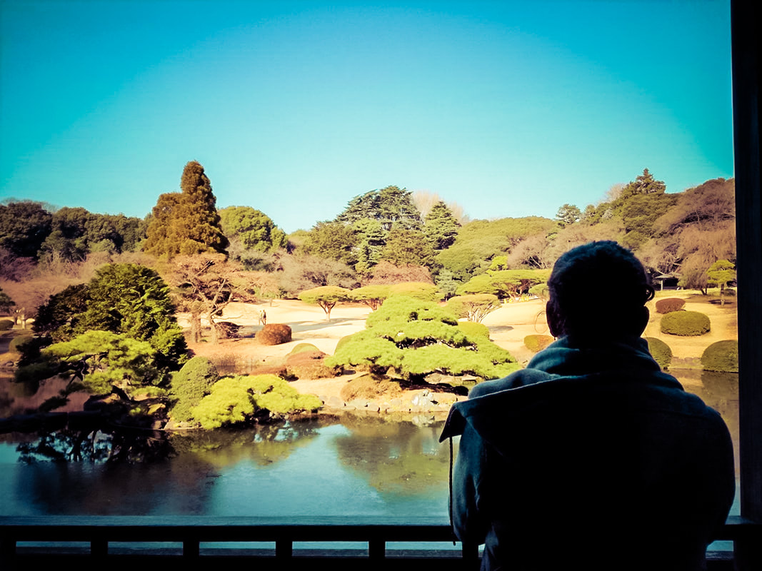 Picture of a woman looking out over a lake and gardens in the background 