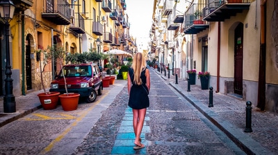 A woman overlooks a pretty street in Palermo, Italy